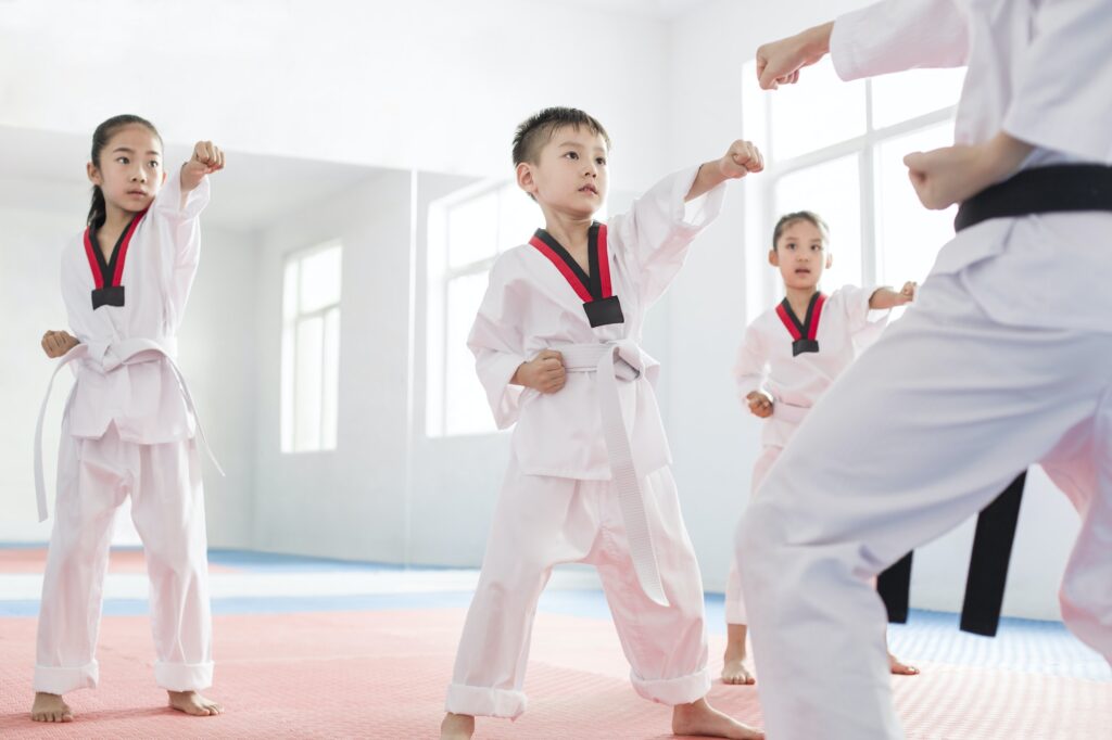 Young instructor teaching children Tae Kwon Do